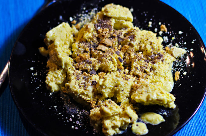 Ein Teller mit Dänischem Butterkeks-Schmarrn, bestreut mit Mandelkrokant, geraspelter Schokolade und Amarettibröseln