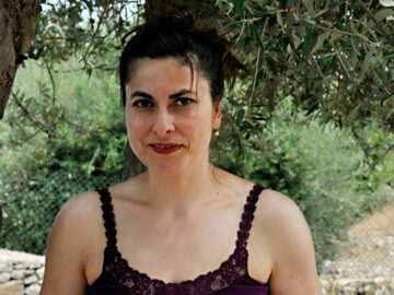 Ein Portraitfoto von Cettina Vicenzino in einem Olivenhain.