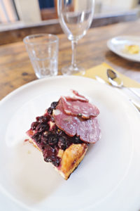 Ein kleines Stück Pan dolce toscano, das mit zwei Scheiben Salami garniert ist.