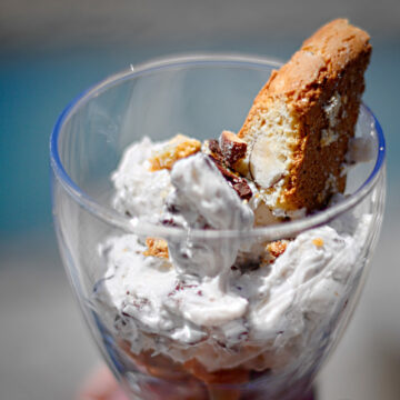 Ein Glas mit einem Tiramisu al Vin Santo, garniert mit einem Cantuccio