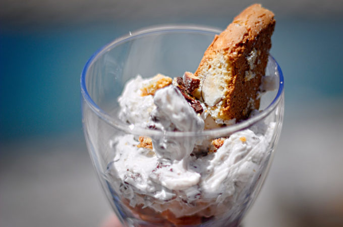 Ein Glas mit einem Tiramisu al Vin Santo, garniert mit einem Cantuccio