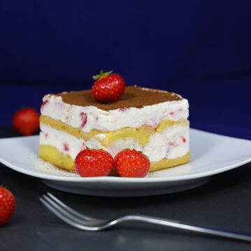 Auf Stück Erdbeer-Tiramisu auf einem Teller, garniert mit frischen Erdbeeren.
