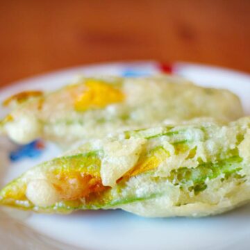 Zwei gefüllte Zucchiniblüten auf einem Teller.