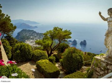 Blick über Capri und das Meer vom Monte Solaro aus. Im Vordergrund ein Garten und eine Statue. Ein Foto von mikolajn / Fotolia.