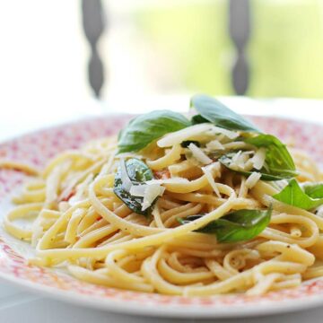 Ein Teller mit Linguine, die mit Basilikum und Zitrone garniert sind.