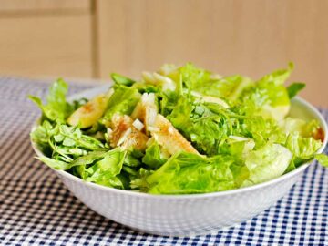 Eine Schüssel mit grünem Salat und Feigen