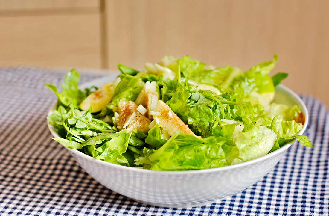 Eine Schüssel mit grünem Salat und Feigen