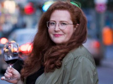 Autorin Liv Fleischhacker mit einem Glas Wein in der Hand