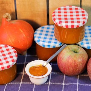 Marmeladengläser, ein Kürbis, zwei Äpfel und ein Töpfchen mit Apfel-Kürbis-Marmelade