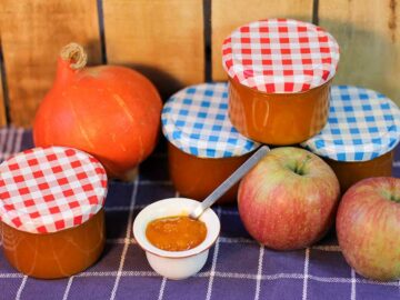 Marmeladengläser, ein Kürbis, zwei Äpfel und ein Töpfchen mit Apfel-Kürbis-Marmelade
