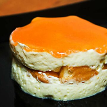 Ein rundes Stück Tiramisu mit fruchtigem Kakipüree glasiert.