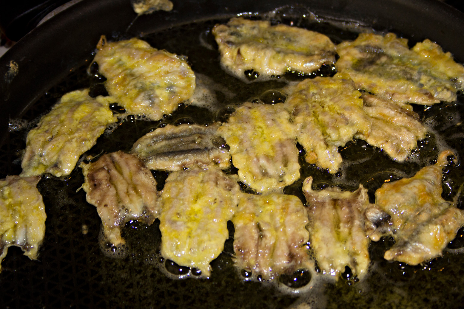 Kleine Sardellenfilets, die in heißem Öl frittiert werden.