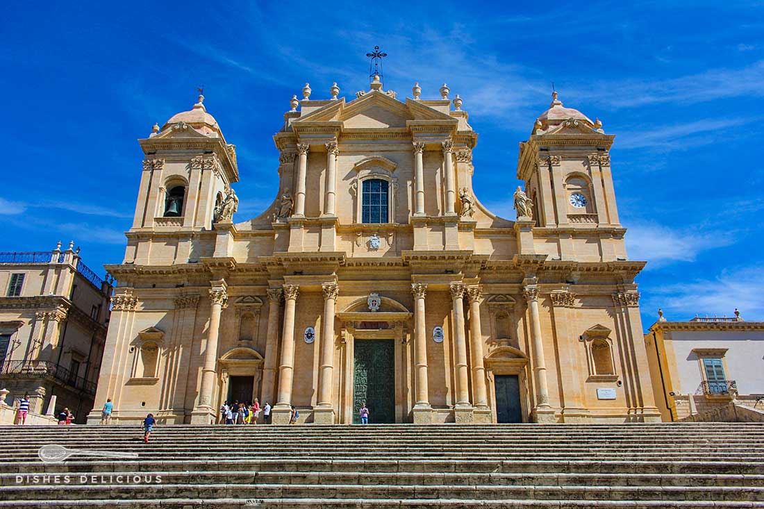 Die Eingangsfront der Kathedrale San Nicolo in Noto. Eine Treppe führt zur Kirche hinauf.