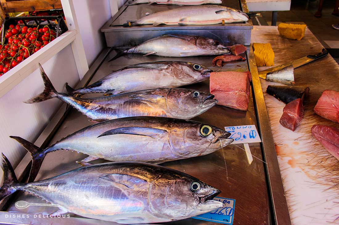 Auf einer Metallplatte liegen fünf frische Thunfische, bereit für den Verkauf auf dem Markt von Syrakus.