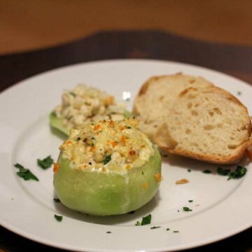 Ein Teller mit einem gefüllten Kohlrabi - im Hintergrund liegen zwei Brotscheiben