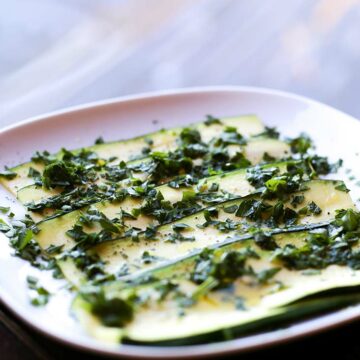 Auf einem Teller marinieren Zucchinischeiben in einer Zitronen-Kräuter-Marinade