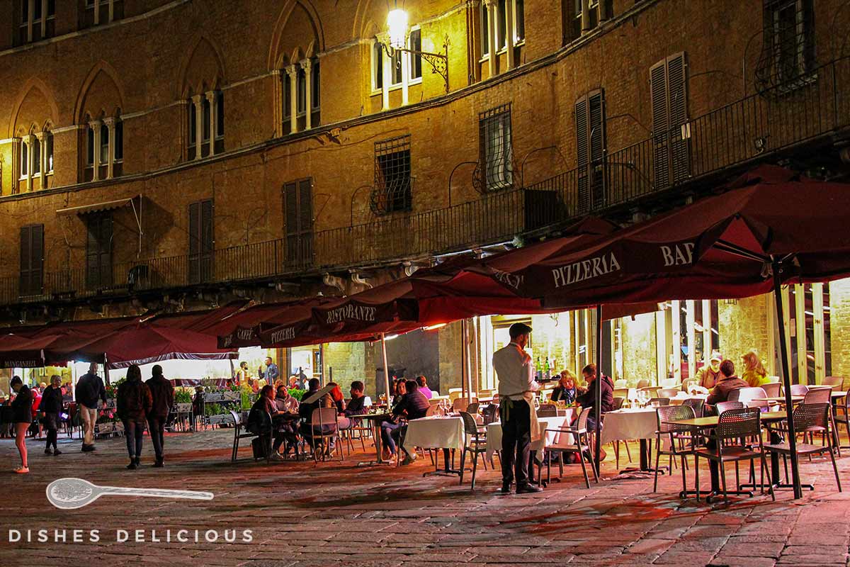 Restaurantbesucher am Abend an der Piazza del Campo in Siena