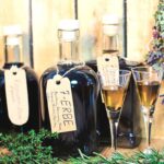 Foto von mehreren Flaschen mit Kräuterlikör und zwei Gläsern mit Likör.