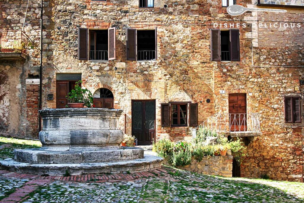 Foto von einem alten Backsteinhaus mit Brunnen in Castiglione d'Orcia.
