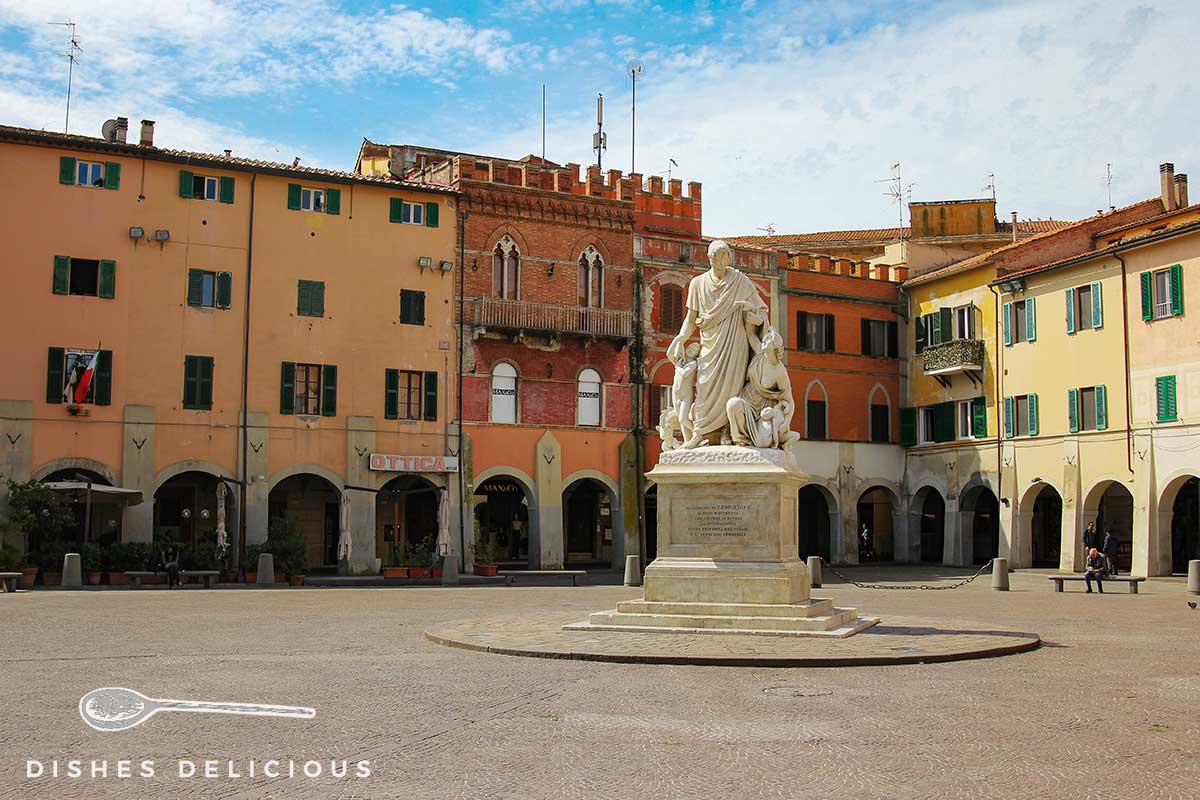 Foto der Piazza Dante - in der Mitte steht eine Statue, dahinter viele alte Gebäude.