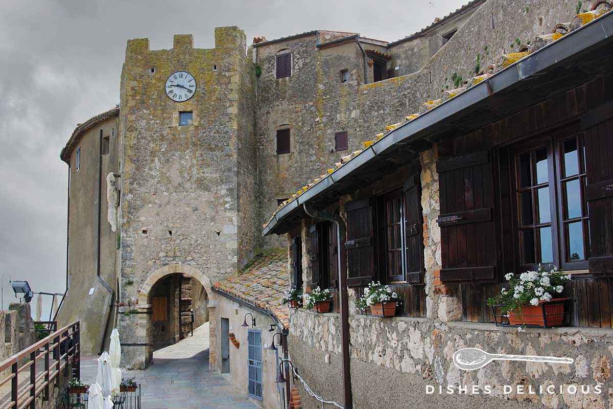 Foto eines wuchtigen Turms in Capalbio, durch einen Bogen geht man in die Altstadt.