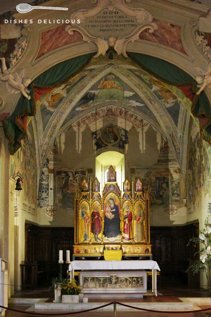 Foto vom Innenraum der Chiesa San Giorgio - im Mittelpunkt steht der Altar, über den sich die verzierte Decke spannt.