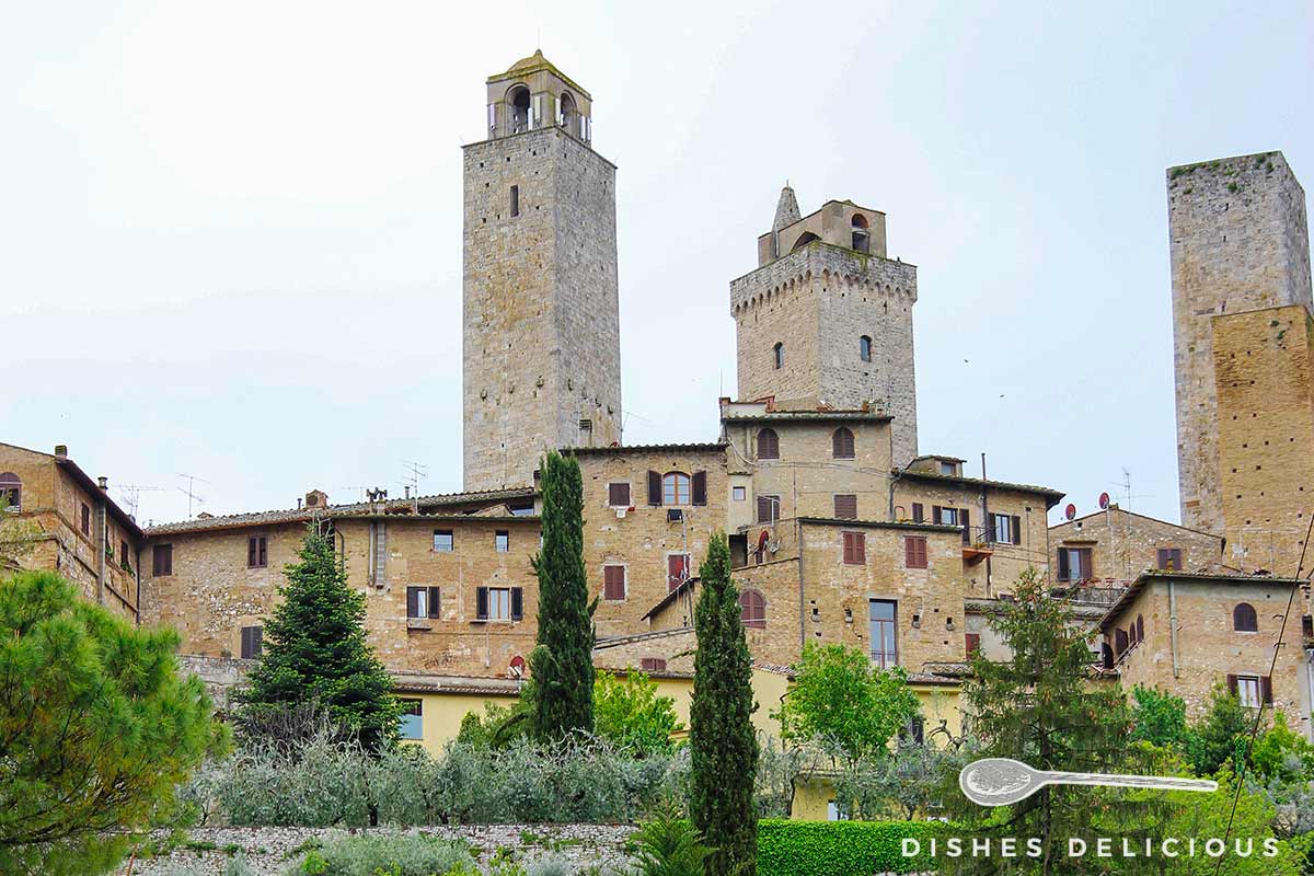 Foto von San Gimignano - man sieht Häuser und vier Türme.