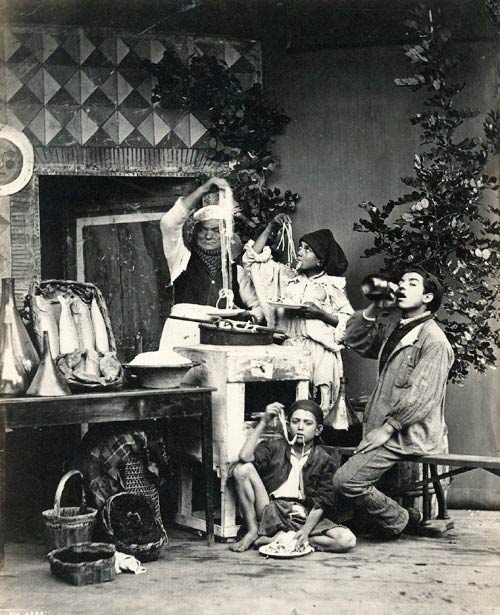 Eine neapolitanische Familie, die mit den Händen Maccheroni verspeist.
