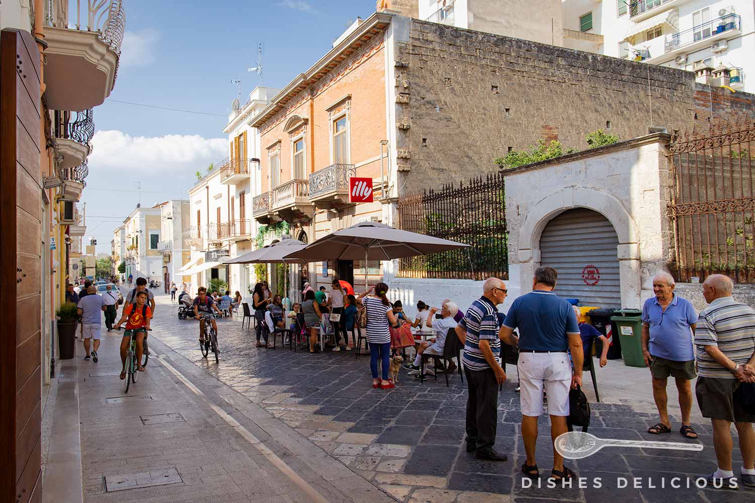 Menschen unterhalten sich vor einem Straßencafe in Manfredonia.