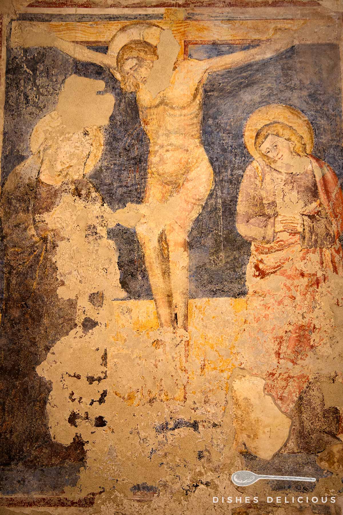 Gut erhaltenes altes Fresko, das Jesus am Kreuz zeigt.