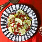 Ein Teller mit einem Salat aus Chicorée, Zitronenscheiben, Granatapfelkernen.