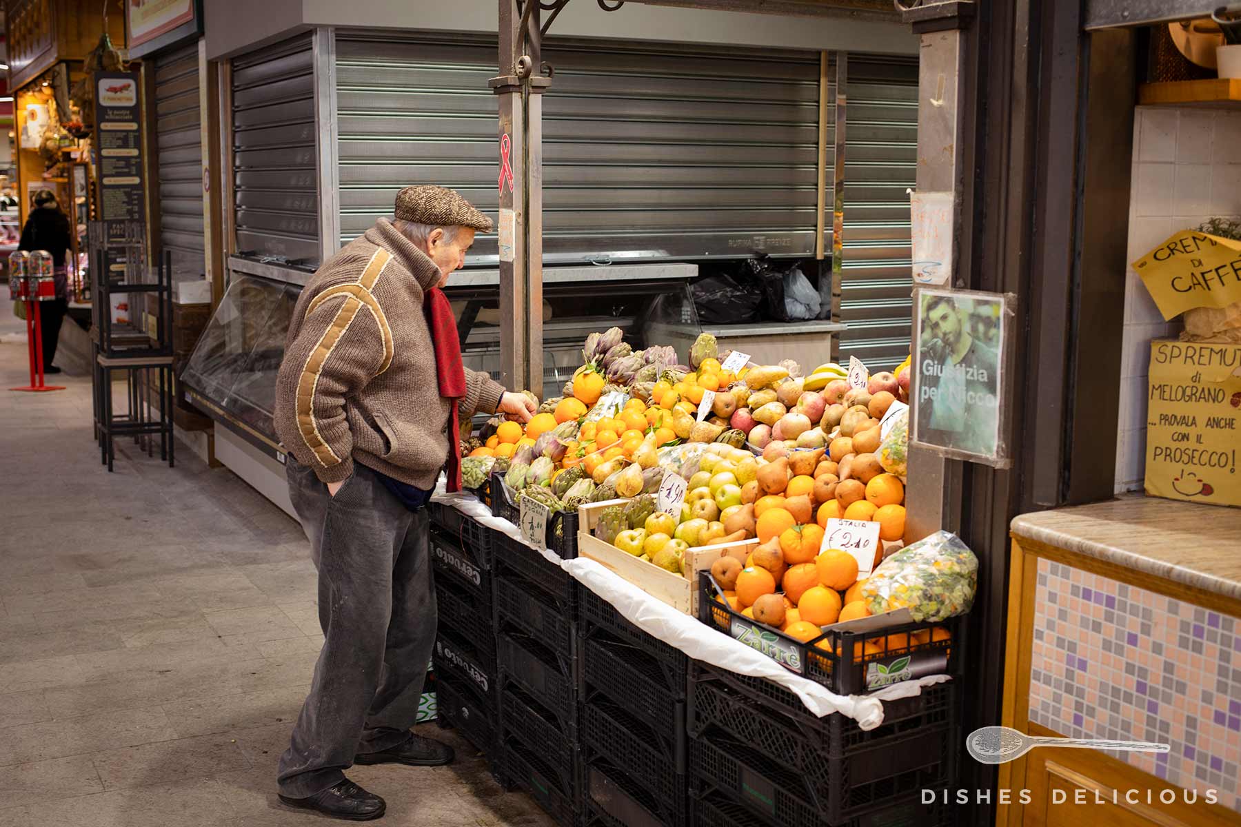 Ein älterer Mann begutachtet Zitronen an einem Obststand auf dem Mercato Centrale in Florenz.