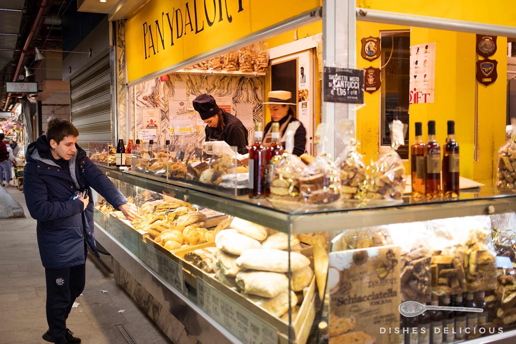 Ein Mann bestellt Backwaren bei einer Bäckerei auf dem Mercato Centrale in Florenz.