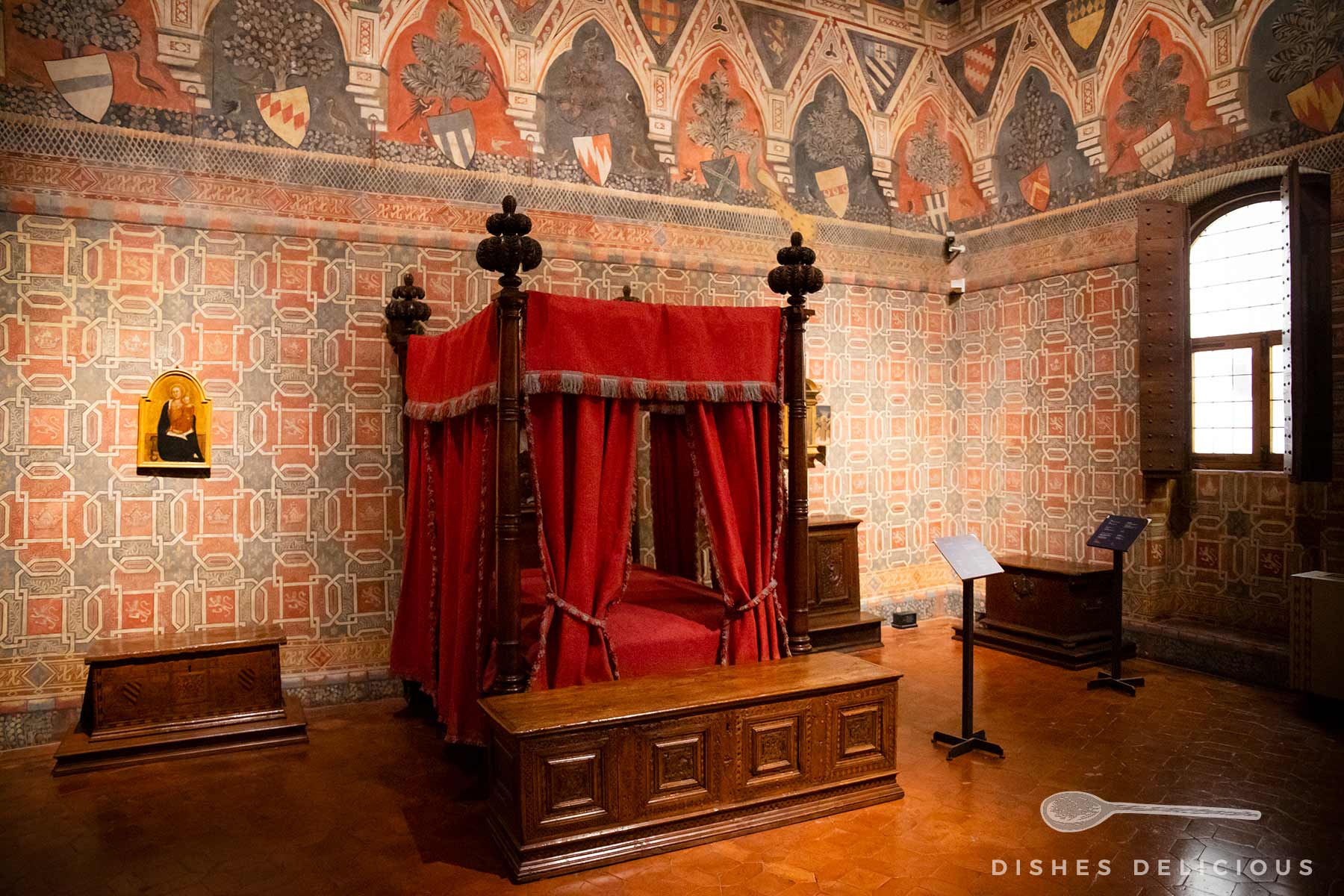 Schlafzimmer im Palazzo Davanzati mit verzierten Wänden und einem Himmelbett.