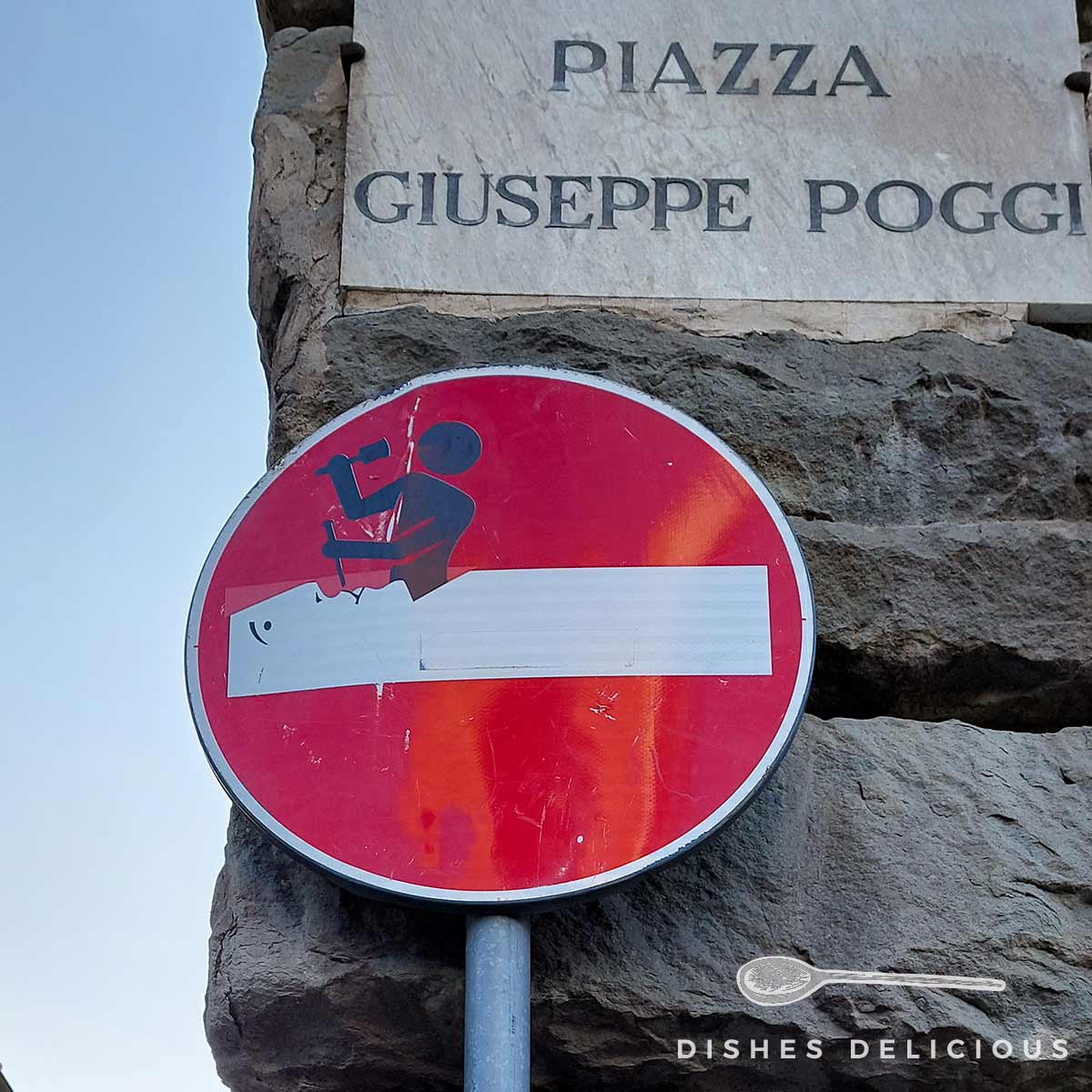 Ein Straßenschild "Durchfahrt verboten", das von Clet in Florenz verändert wurde.