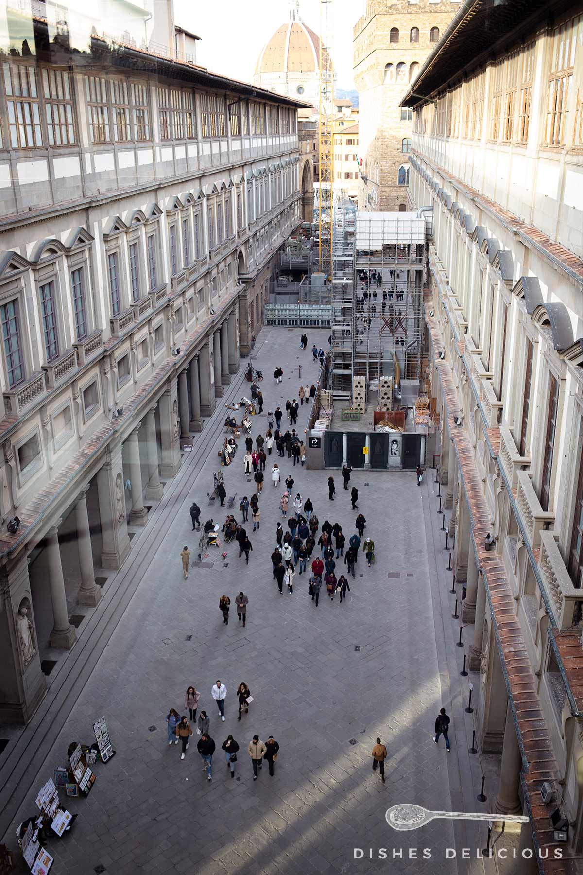 Blick auf den Innenhof der Uffizien, in dem Menschen flanieren.