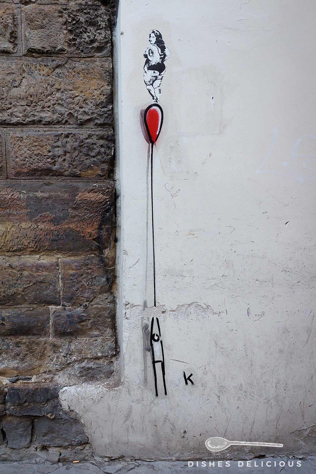 Street Art in Florenz: ein Männchen hält einen roten Ballon, auf dem eine Frau steht.