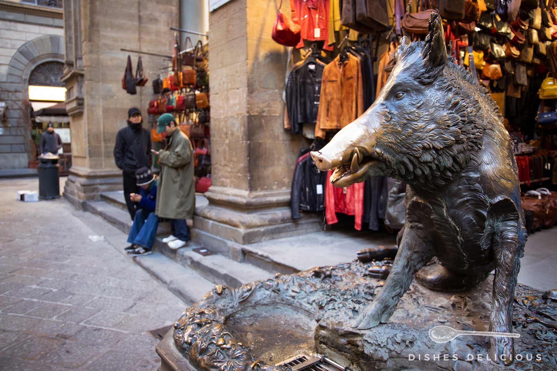 Bronzefigur eines Wildschweins auf einem Brunnen.