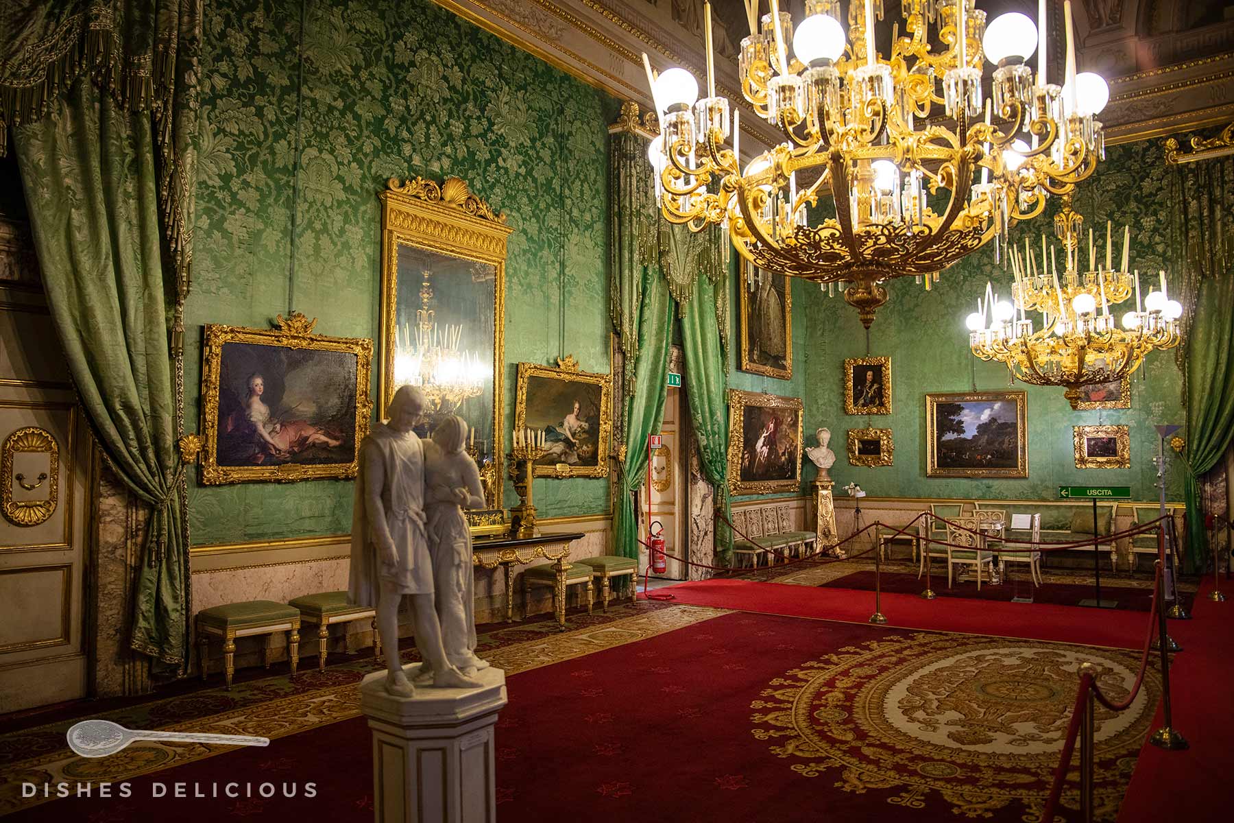 Ein prachtvoll mit Gemälden, Teppichen, Skulpturen und Kronleuchtern ausgestatteter Saal im Palazzo Pitti.
