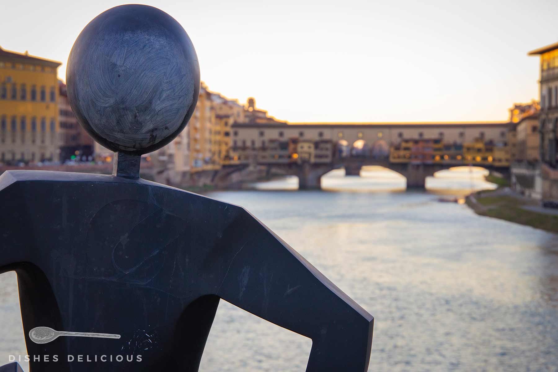 Eine Skulptur, im Hintergrund die Ponte Vecchio.