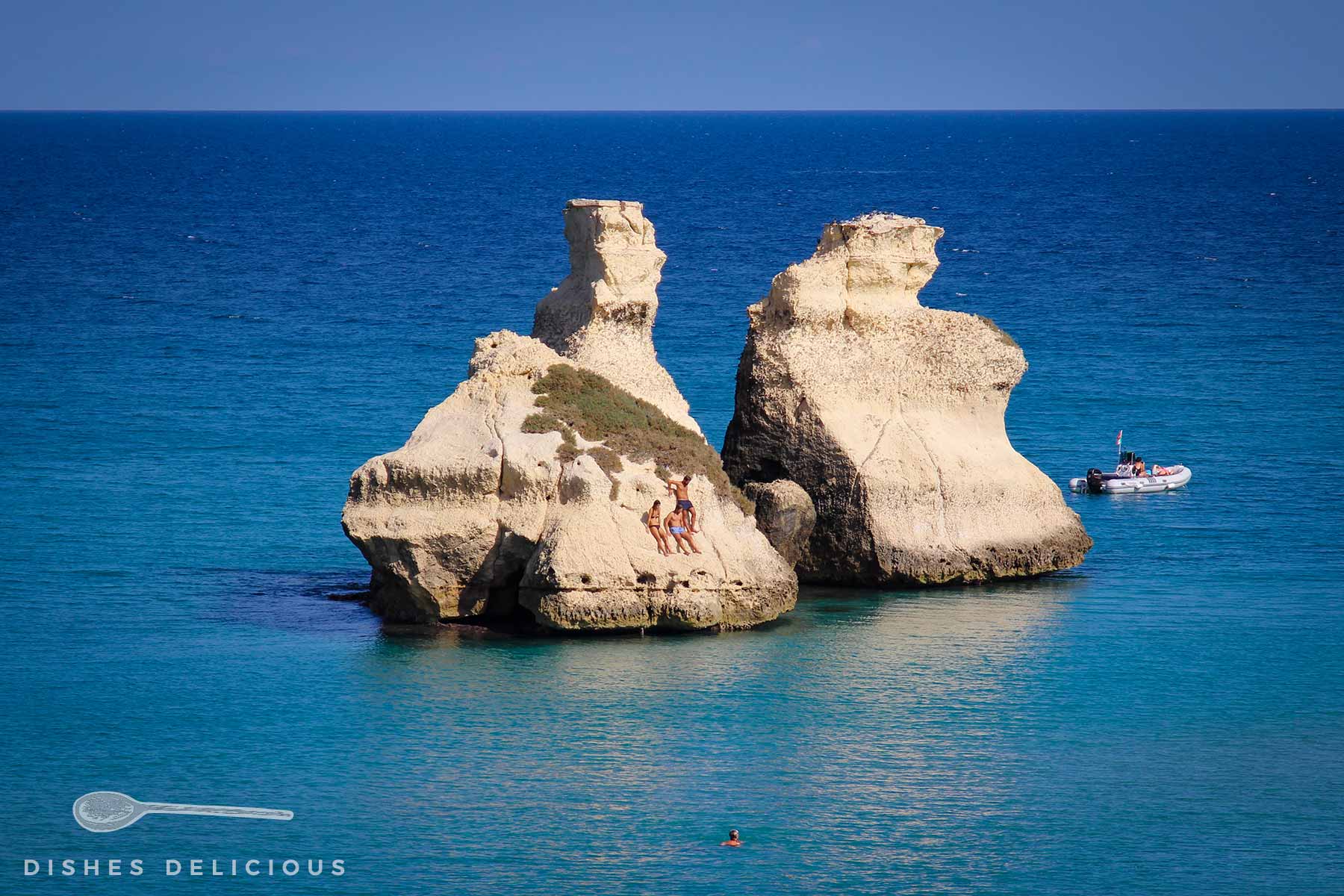 Drei Menschen sonnen sich auf den Due Sorelle im Meer - zwei Felsen am Badestrand an der Ostküste des Salento.