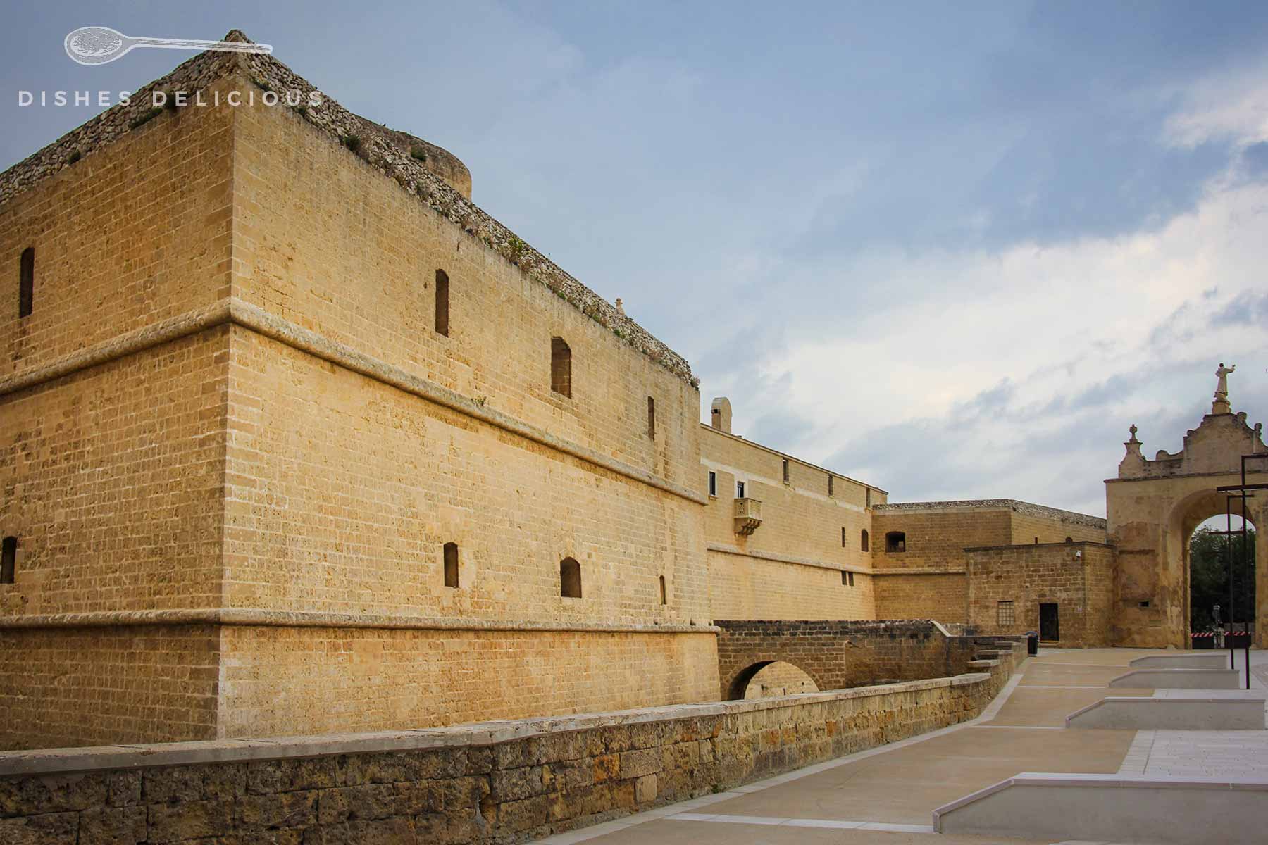 Hohe Wehrmauern und davor ein Graben: das Castello von Copertino