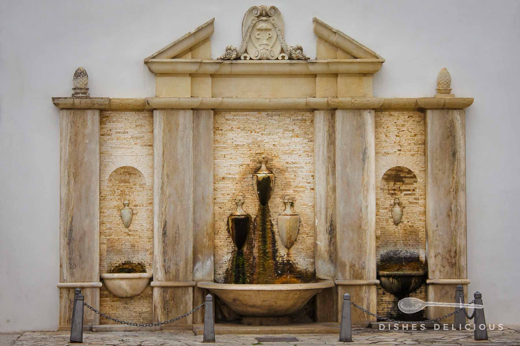 Brunnen mit drei Becken und in die Brunnenmauer eingelassenen Amphoren an der Piazza Giuseppe