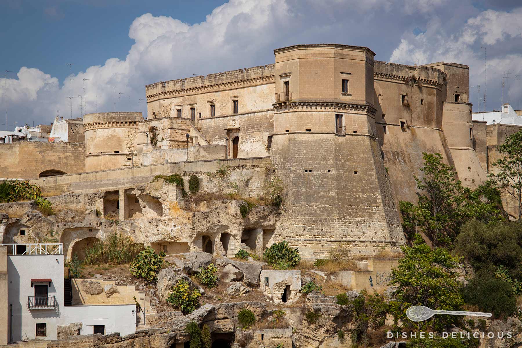 Die Burg von Massafra auf dem Felssporn der Stadt. Die Burg wirkt verwachsen mit dem steinernen Untergrund.
