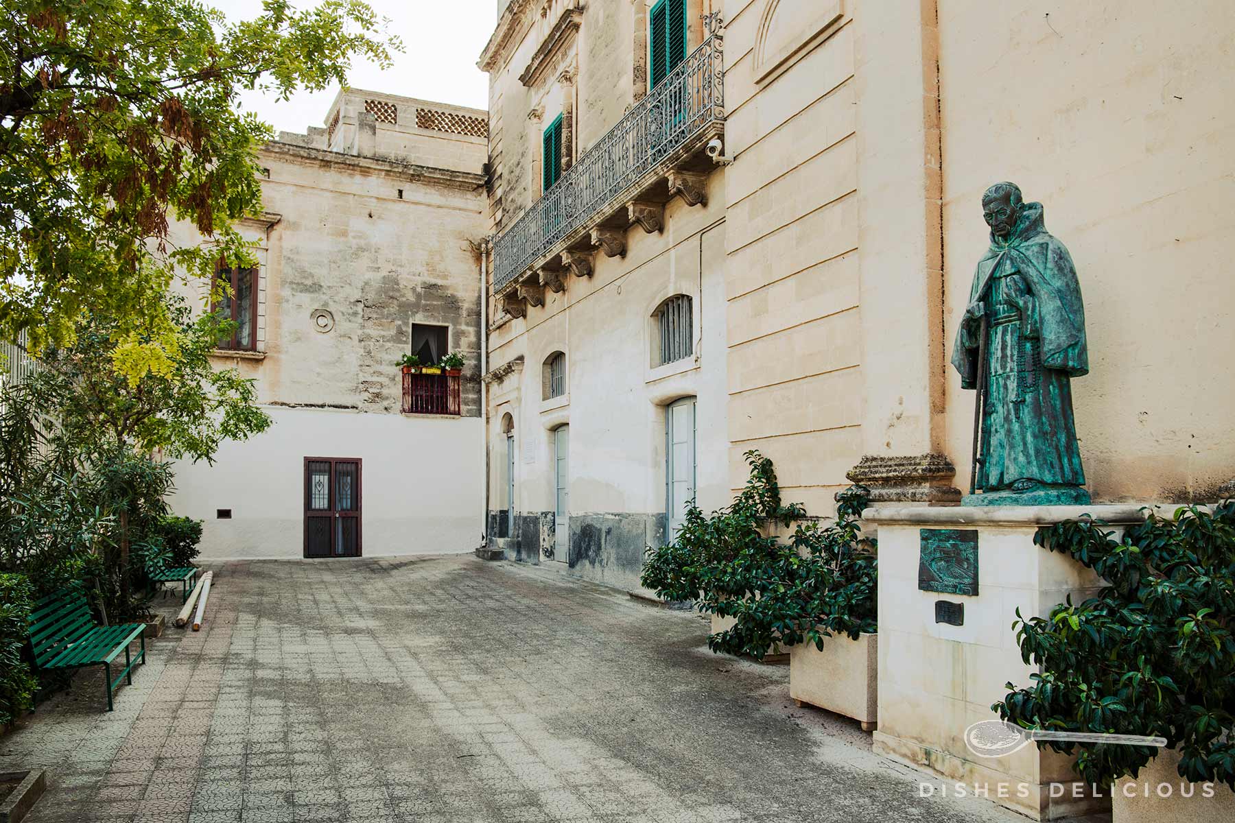 Vorhof des Klosters Gesù Bambino: rechts steht eine Heiligenstatue, links zwei Bänke.