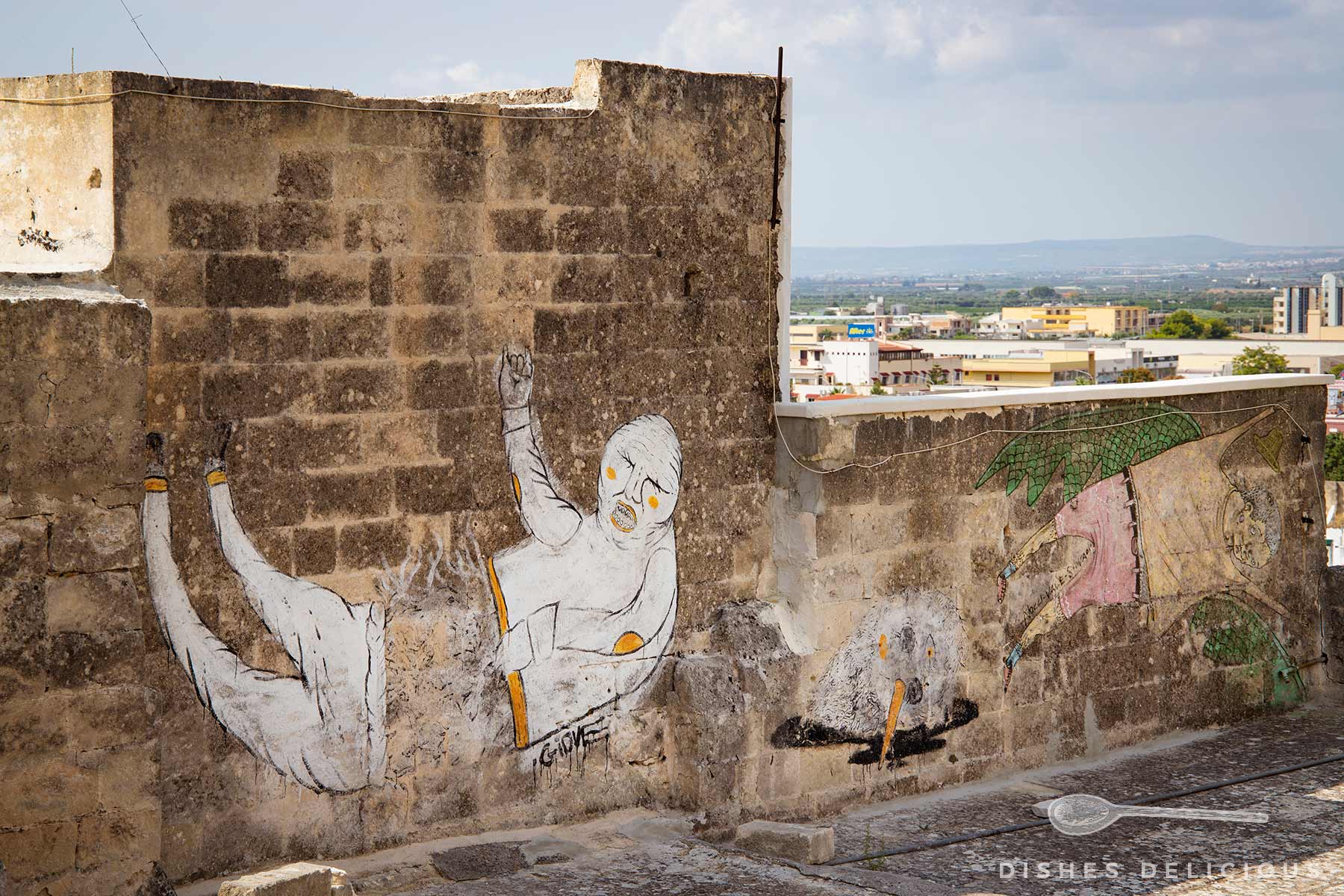 Street-Art an einer Mauer: ein durchtrennter Mensch und ein Mensch mit Flügeln.