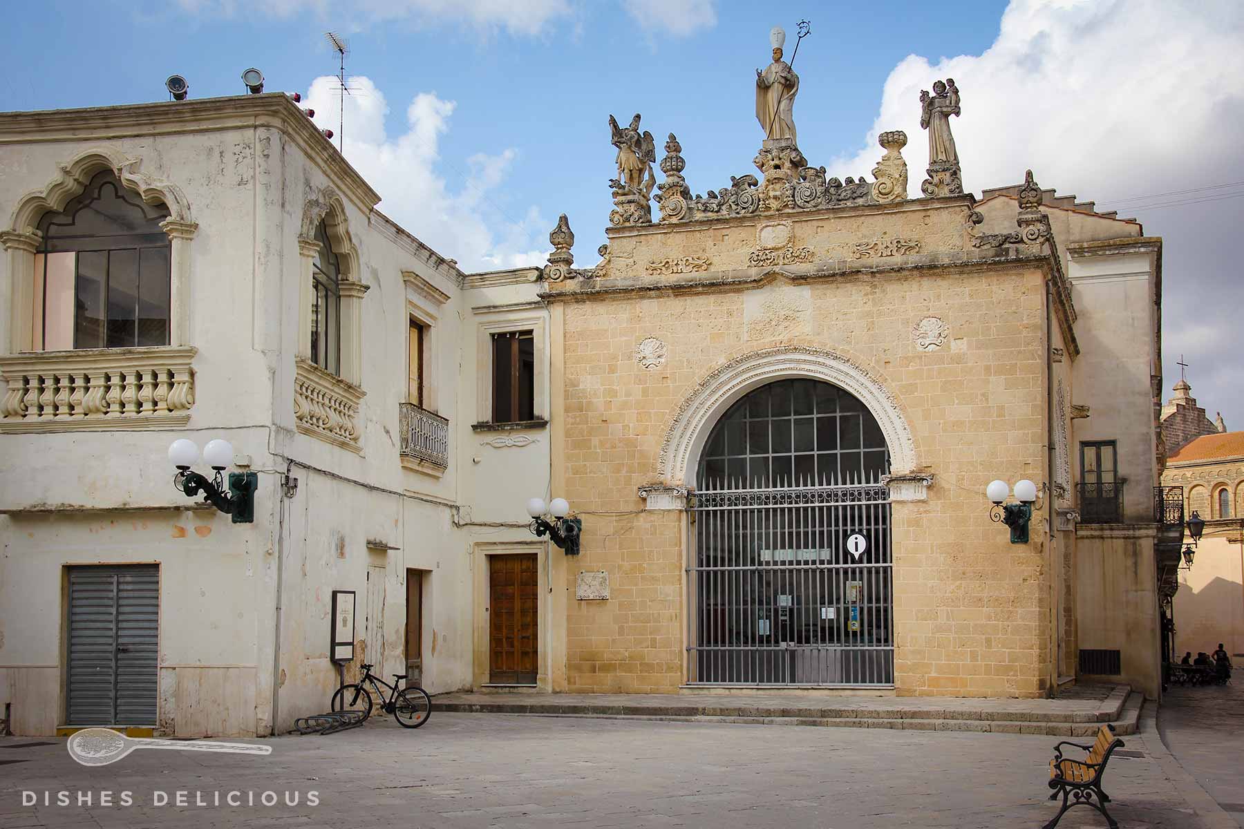 Der alte, einstöckige Palazzo Sedile an der Piazza Salandra. Sein großes Tor ist mit Gittern verriegelt, drei Heiligenstatuen bestücken sein Dach.