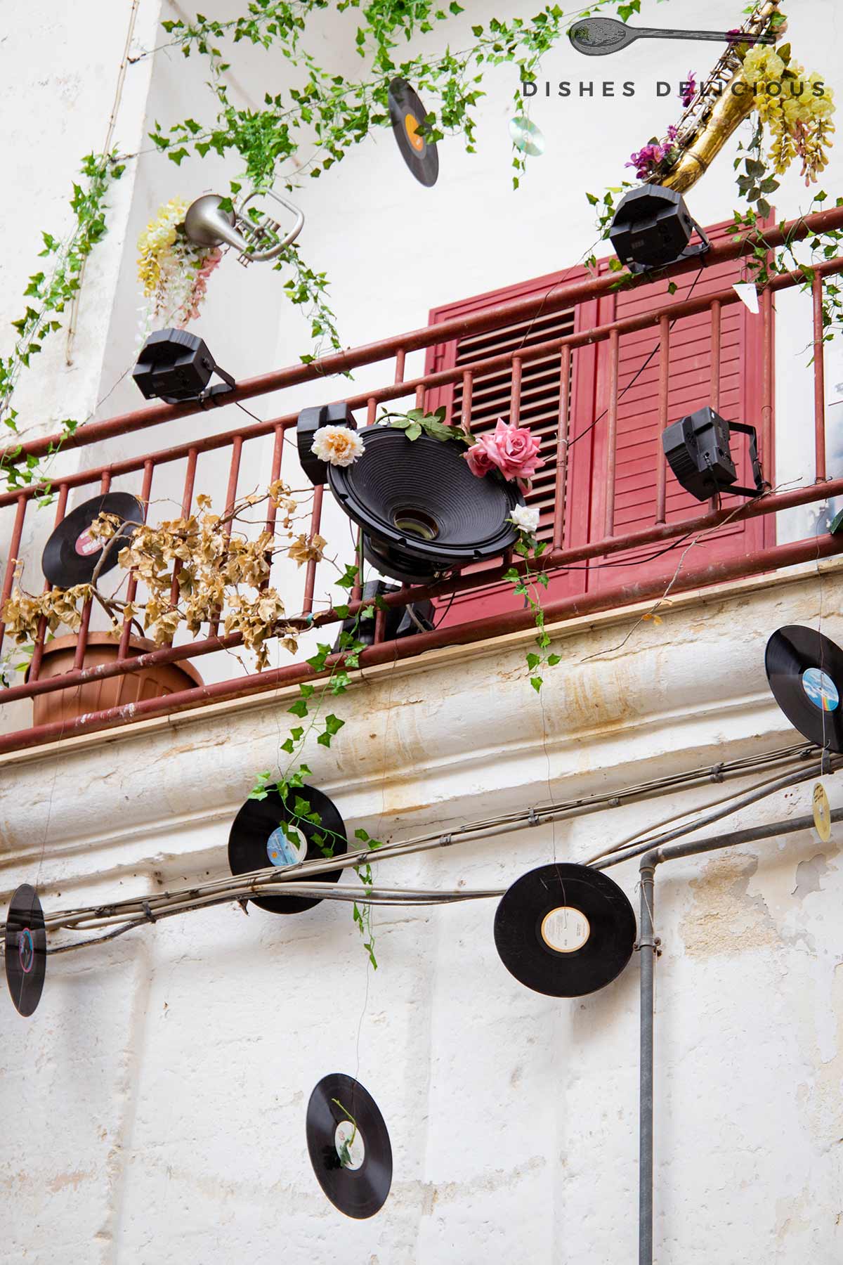 Ein Balkon, behängt mit Schallplatten, einer Trompete und Lautsprecher.