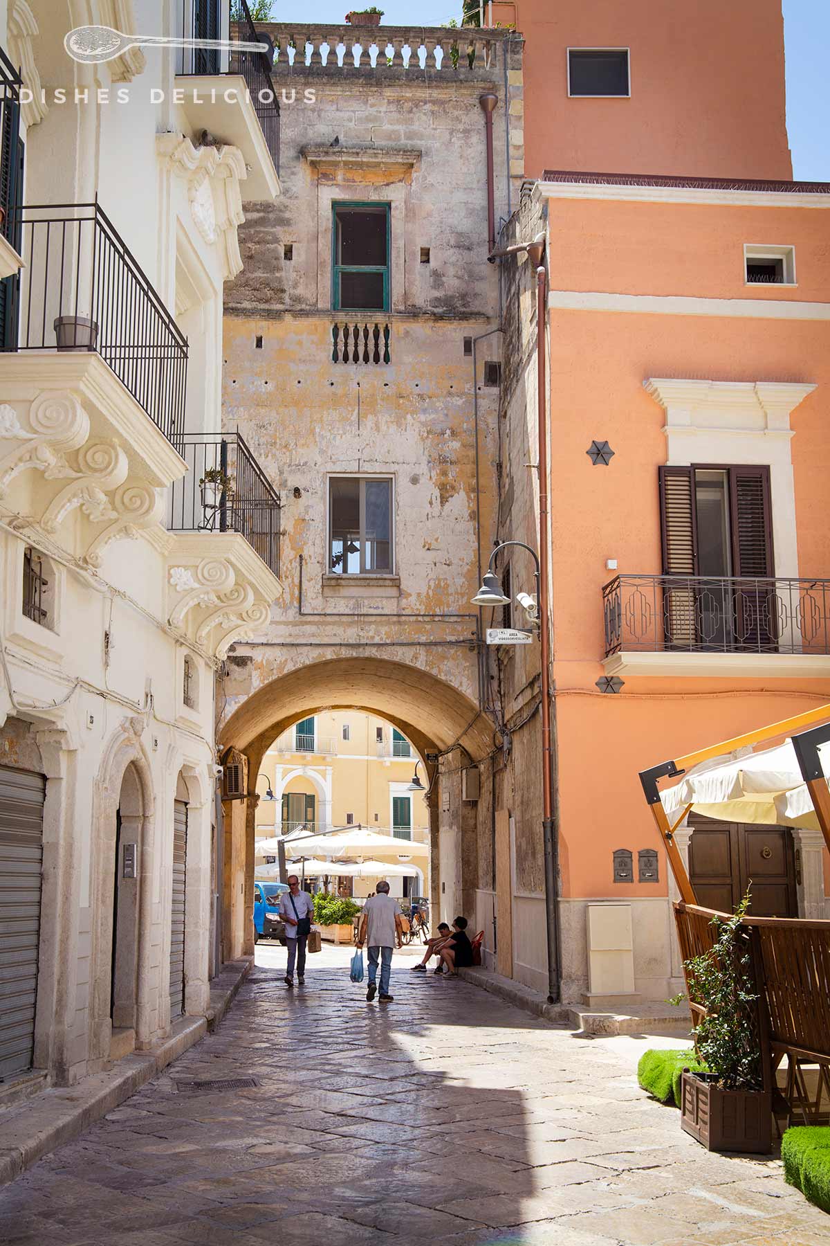 Palazzi am Eingang der Altstadt von Gravina in Puglia, ein durch ein Haus gebauter Durchgang führt zu einem Platz.