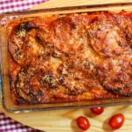 Eine Ofenform mit einer Parmigiana di melanzane: überbackene Auberginenscheiben in Tomatensauce